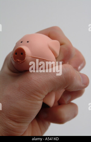 Hand squashing a stress toy pig Stock Photo