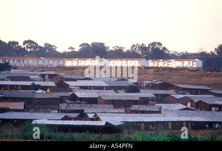 Slum housing in Kibera with modern low cost but new homes in the background Nairobi Kenya East Africa Stock Photo