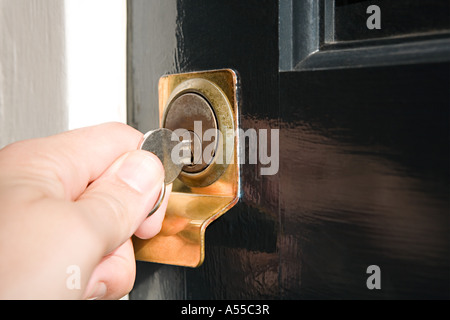 Person putting key in keyhole Stock Photo