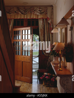 Half-glazed open door into traditional hall with view of outside Stock Photo