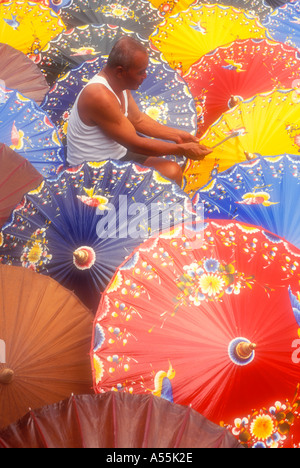 Man painting colourful umbrellas in Yogyakarta Java Indonesia Model Released Stock Photo