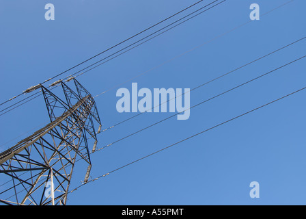 Electricity pylon and power lines with a plain blue sky. Stock Photo