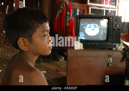 Painet ix1881 cambodia boy watching tv powered by 12 volt car battery home trac village kampong cham country developing Stock Photo