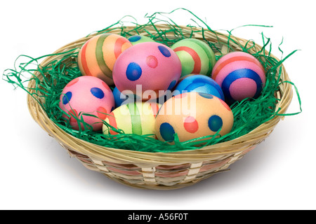 Bunch of colored Easter eggs in a wooden basket. Isolated on a white background. Stock Photo