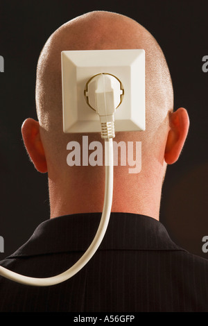 Man with plug and socket on back of head Stock Photo