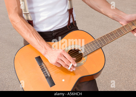Man playing guitar, mid section Stock Photo