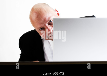 Man looking from behind lap top, smiling Stock Photo