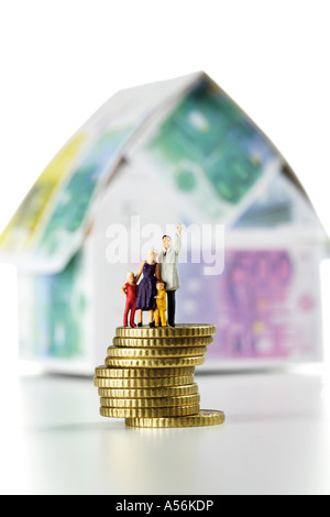 Figurines on coins in front of house of Euro notes Stock Photo