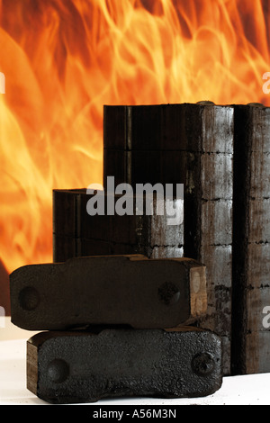 Piled briquettes, fire in background Stock Photo