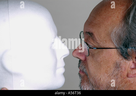 Man looking white mannequin head Stock Photo