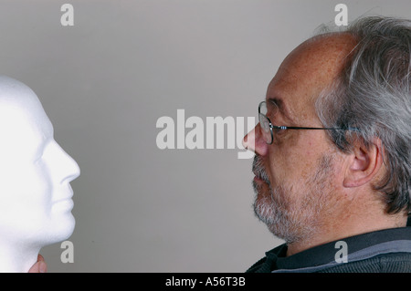 Man looking white mannequin head Stock Photo