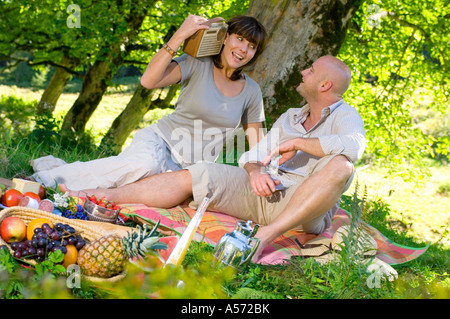 Couple having picnic under tree Stock Photo