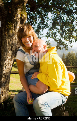 Couple sitting under tree Stock Photo