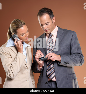Businessman and woman using mobile phone and palmtop Stock Photo