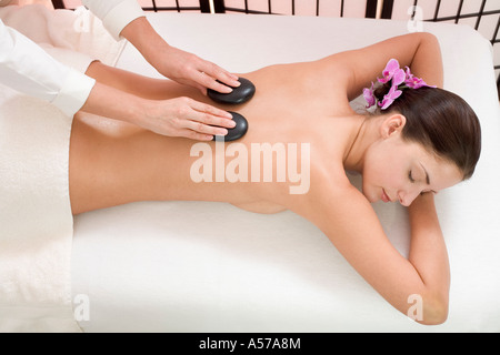 Young woman receiving hot stone massage, elevated view Stock Photo