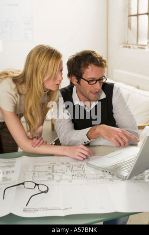 Young man and woman using laptop, elevated view Stock Photo
