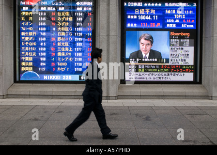 Man looking at stock market index board on Tokyo Street Japan 2006 Stock Photo