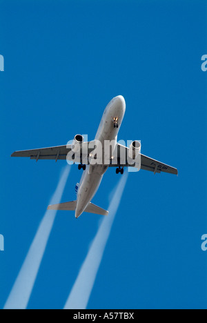 Jet charter commercial airline high altitude con condensation vapour trail blue sky plane flying charter tourism travel Stock Photo