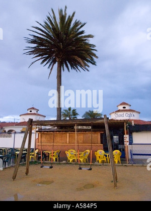 A deserted and wet children's playground in winter on the beach promenade at Torrox Costa, Costa del Sol, Malaga Andalusia Spain Stock Photo