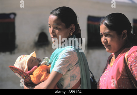 Nepali woman holding sleeping baby near Stupa of Bodhnath in Kathmandu Nepal Stock Photo
