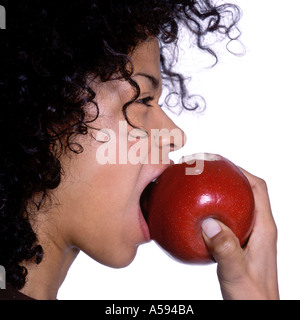 Young Woman With Curly Hair Eating Apple Stock Photo
