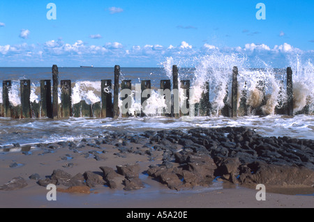 WAVES CRASHING OVER WORN SEA DEFENCES AT HAPPISBURGH NORFOLK EAST ANGLIA England UK Stock Photo