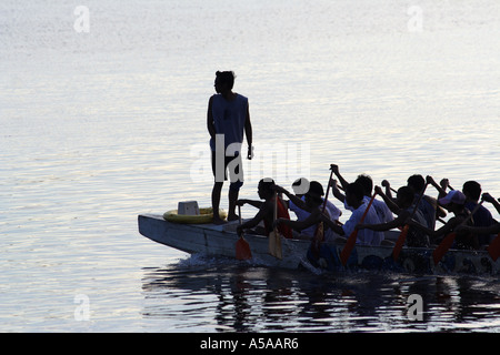 Manila, Philippine Islands, Manila Baywalk, captain and team rowing dragon boat at sunset Stock Photo