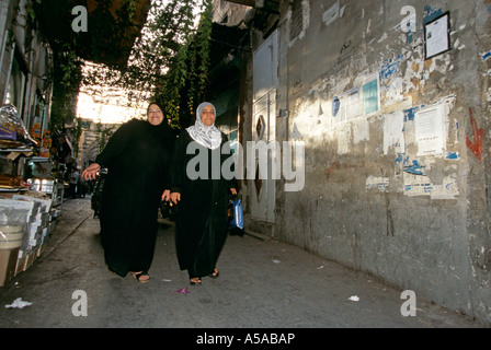 Two ladies walking along the street market in Damascus Syria Stock Photo