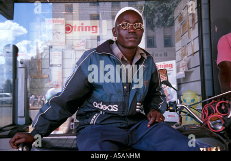 Rider on motorbike at shopfront, Nairobi, Kenya Stock Photo