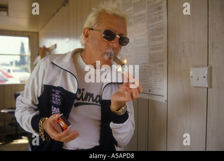 Jimmy Saville TV personality with lighting up  his trade mark cigar Yorkshire Circa 1985 HOMER SYKES Stock Photo