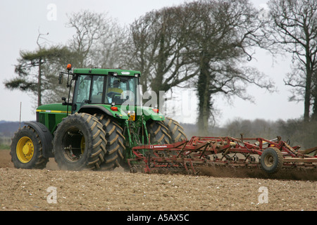 Iconic image of British farming as a modern tractor ploughs an arable field in Norfolk East Anglia England UK GB Britain Stock Photo