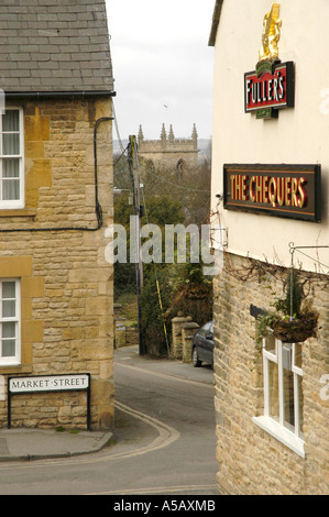 The Chequers public house in Market Street, Chipping Norton, looking down Church Street towards St Marys church, down the hill Stock Photo