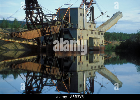 floating abandoned gold dredge reflecting in pond Chatanika Gold fields north of Fairbanks Alaska Stock Photo