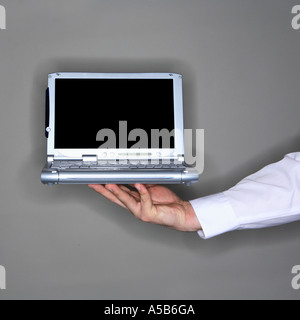 Hand holding laptop computer with blank screen Stock Photo