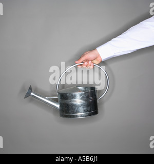 Watering can in outstretched arm Stock Photo