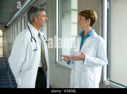 Two physicians having discussion in hospital corridor. Stock Photo