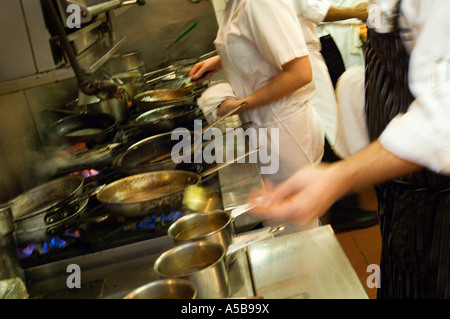 Restaurant kitchen staff busy at work at the stove. Stock Photo