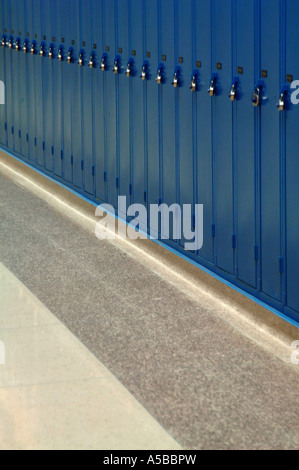 Row of locked blue lockers in school hallway with locks. Stock Photo