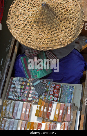 Spice packet seller in conical straw hat Damnoen Saduak floating market Thailand Stock Photo