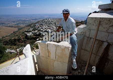A construction worker working at a site on a cliff  Stock Photo
