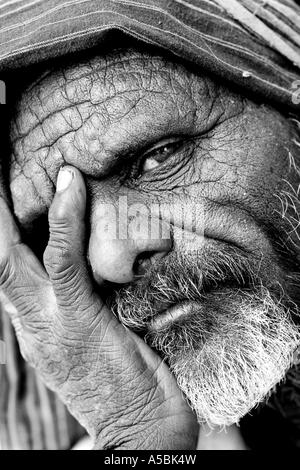 Old Indian man with his head in his hands. Andhra Pradesh, India. Black and White Stock Photo