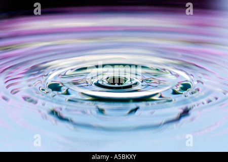 Water drop abstract against black and pink background. Water on a plate mirror with reflected colour Stock Photo