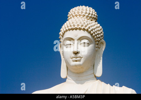 White Buddha statue against blue sky in South India Stock Photo