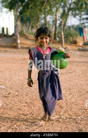 Young poor Indian girl carrying water pot from a village water tap. Andhra Pradesh, India Stock Photo