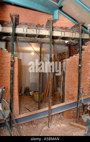 ACROW PROPS WITH STRONG BOYS HOLDING A SUPPORTING WALL BEFORE A RSJ IS FITTED TO ALLOW THE ENLARGEMENT OF A WALL OPENING Stock Photo