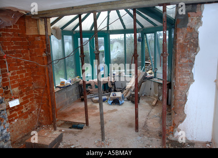 ACROW PROPS WITH THE LOAD SPREAD BY A PAIR OF SCAFFOLDING PLANKS HOLDING A SUPPORTING WALL Stock Photo