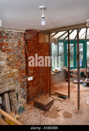 ACROW PROPS WITH THE LOAD SPREAD BY A PAIR OF SCAFFOLDING PLANKS HOLDING A SUPPORTING WALL Stock Photo