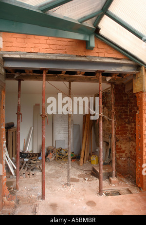 ACROW PROPS SUPPORTING AN RSJ WHILE CONCRETE PADSTONES SET TO ALLOW THE ENLARGEMENT OF A WALL OPENING Stock Photo