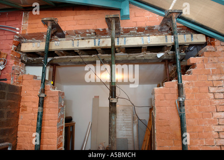 ACROW PROPS WITH STRONG BOYS HOLDING A SUPPORTING WALL BEFORE A RSJ IS FITTED TO ALLOW THE ENLARGEMENT OF A WALL OPENING Stock Photo