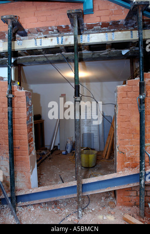 ACROW PROPS WITH STRONG BOYS HOLDING A SUPPORTING WALL BEFORE A RSJ IS FITTED TO ALLOW THE ENLARGEMENT OF A WALL OPENING Stock Photo